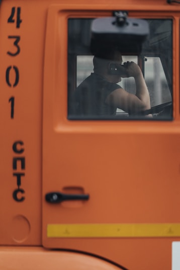 man in black t-shirt and black shorts in orange car