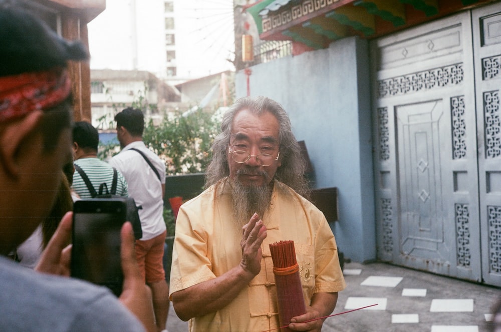 woman in yellow shirt holding brown stick