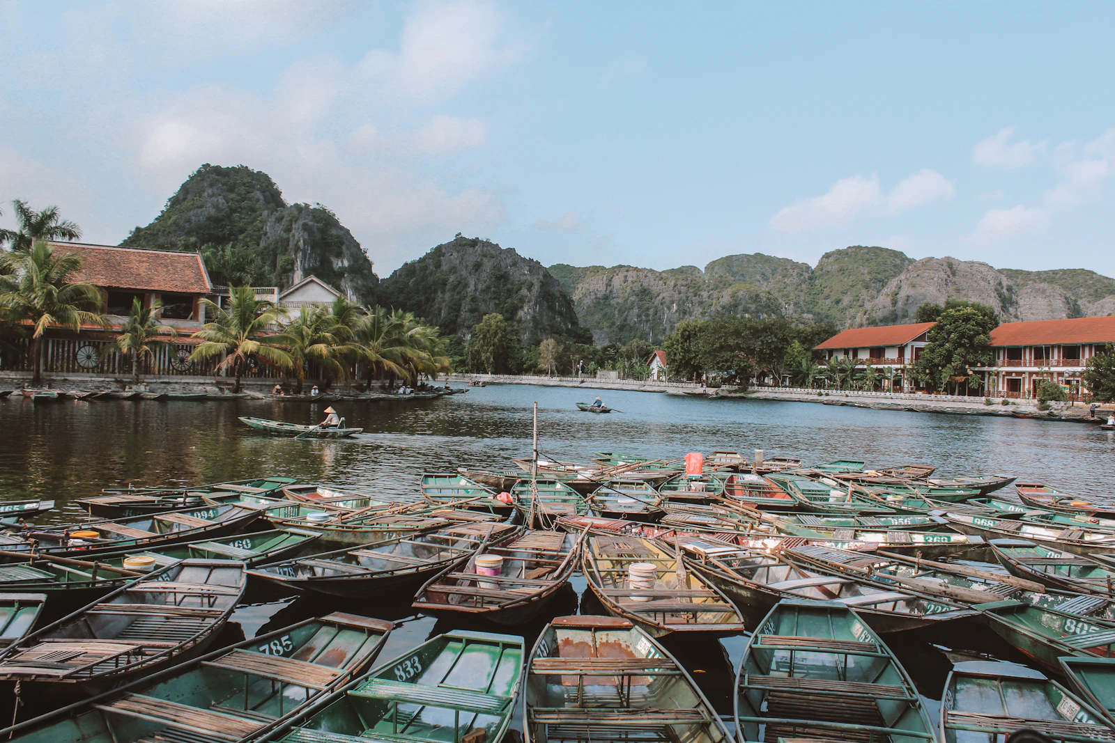 Rowing boats waiting on the water at Tam Coc in Ninh Binh, Vietnam