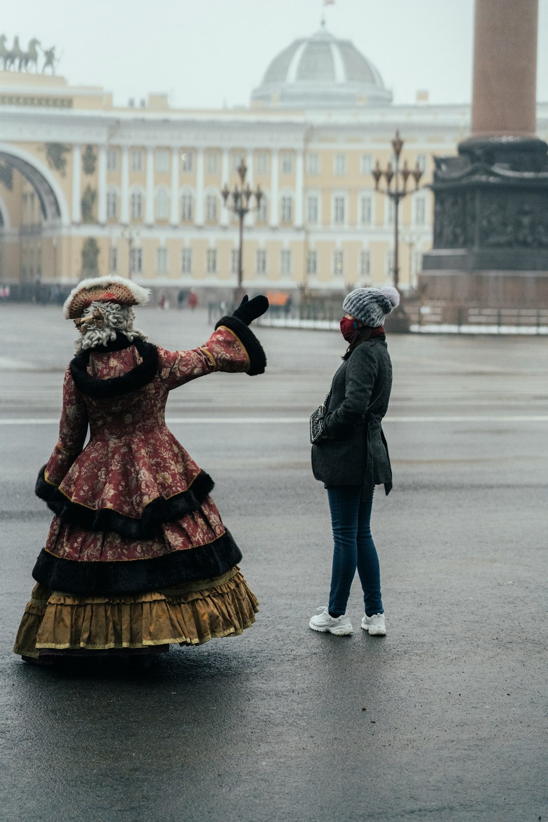 man and woman in black jacket and red dress walking on street during daytime