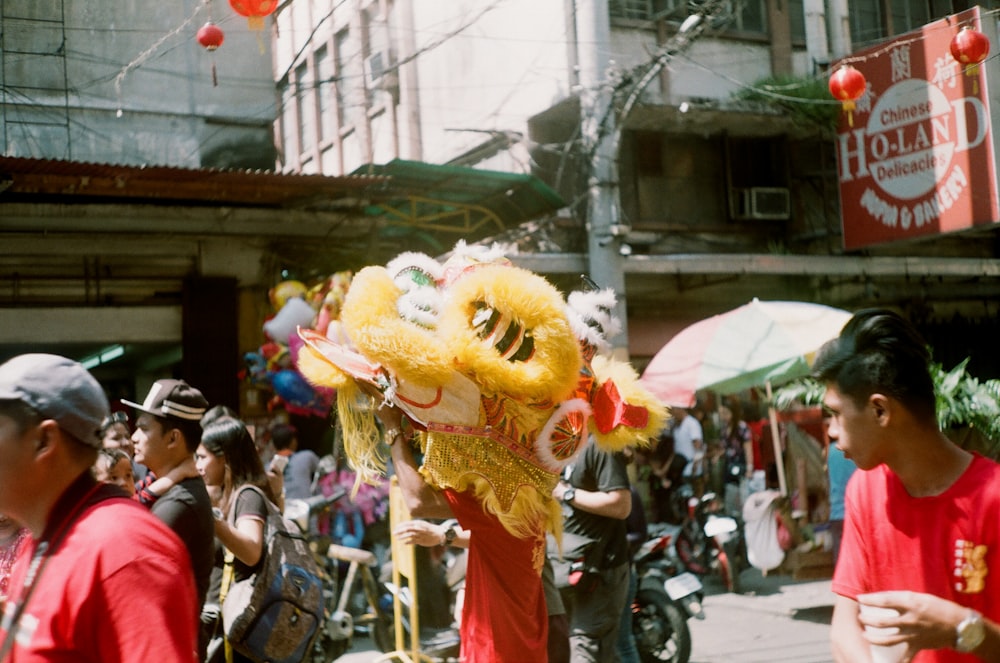 people in yellow and red costume walking on street during daytime