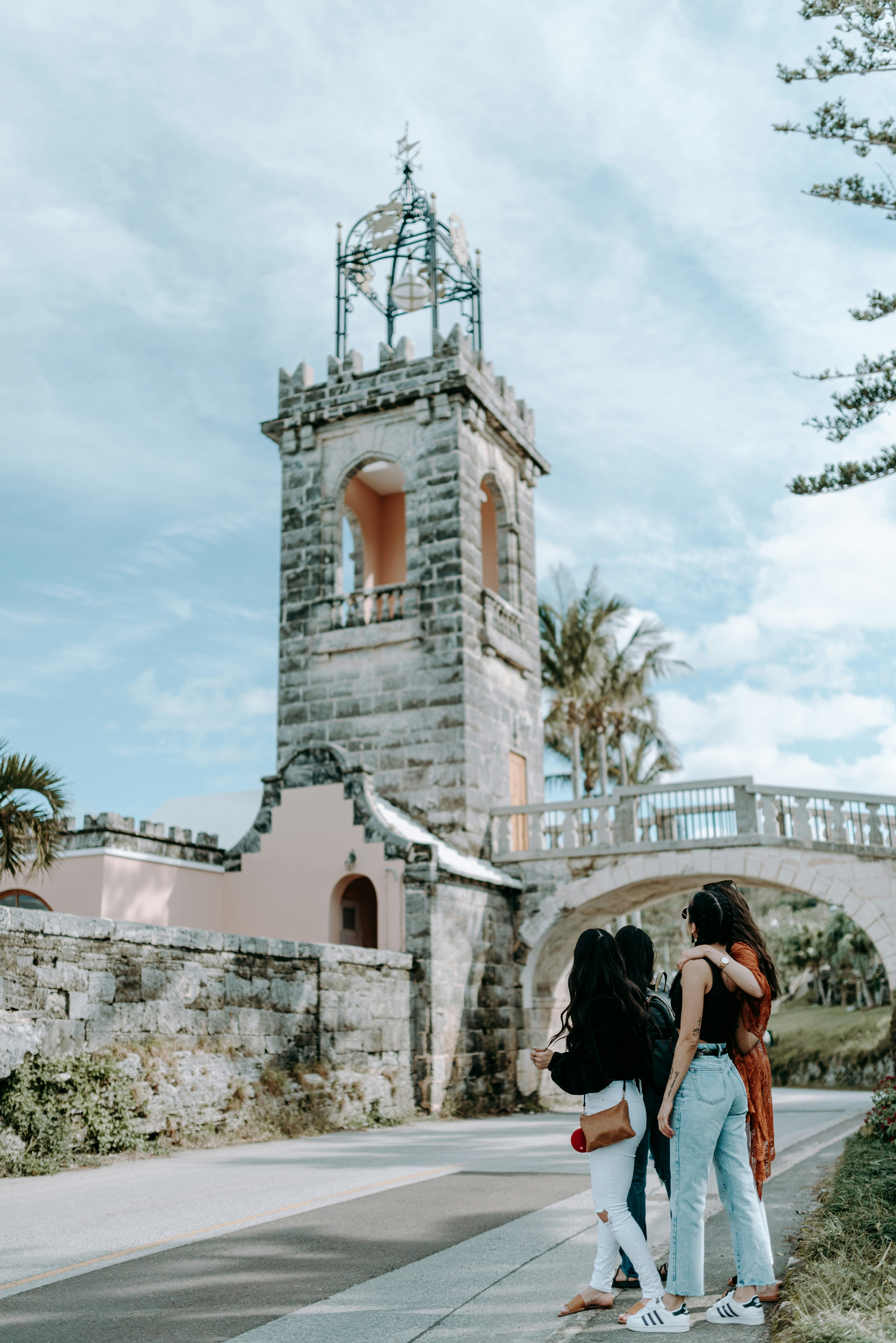 woman in black dress standing near white concrete building during daytime