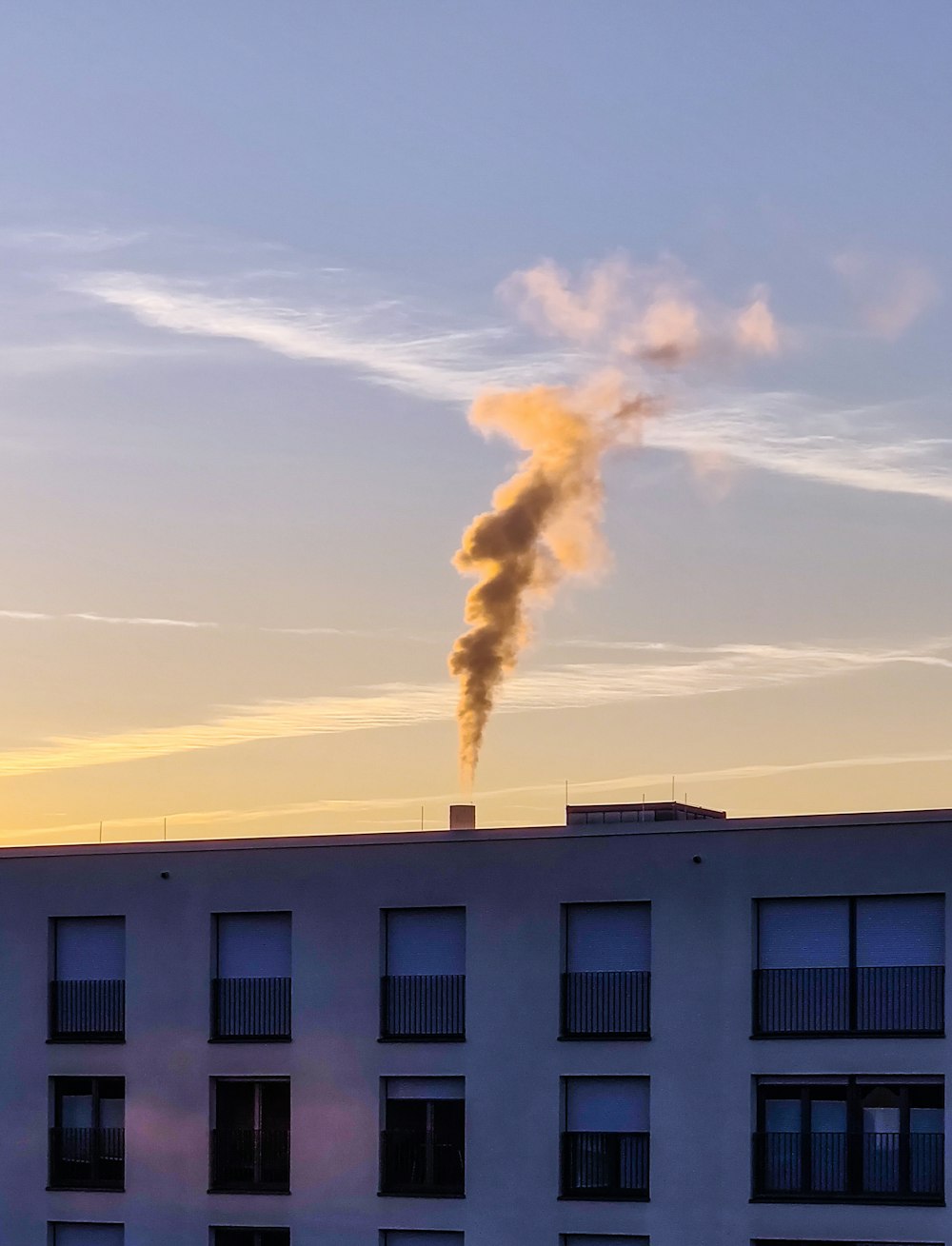 Weißes Betongebäude unter weißen Wolken tagsüber