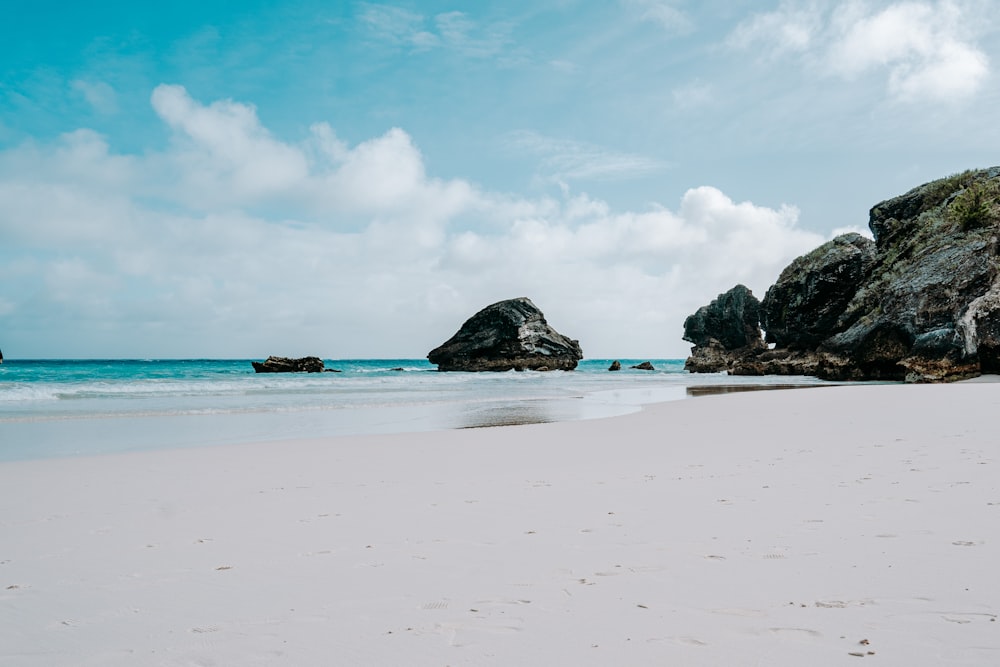 green and brown rock formation on sea shore during daytime