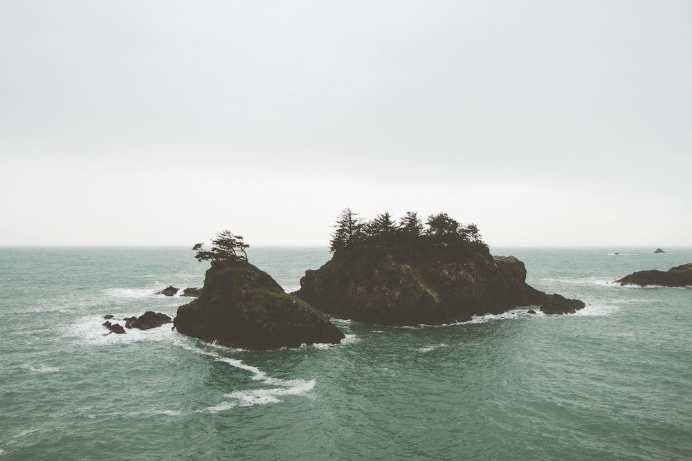 brown rock formation on body of water during daytime