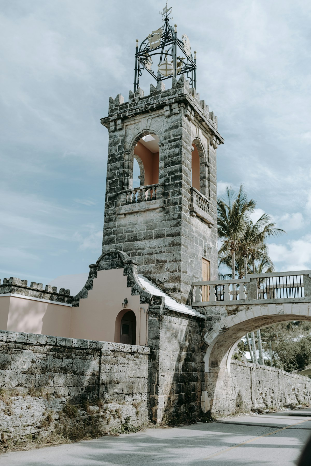 Historic Bermuda limestone clock tower with palm trees, a colonial-era landmark near St. George's