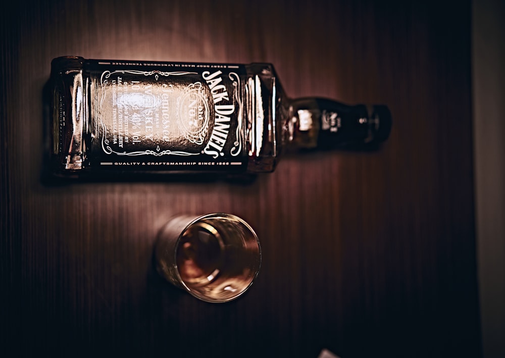 Botella de Jack Daniels junto a un vaso transparente