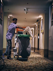 man in blue dress shirt and blue denim jeans holding green plastic bag
