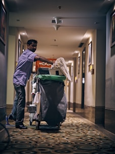 man in blue dress shirt and blue denim jeans holding green plastic bag
