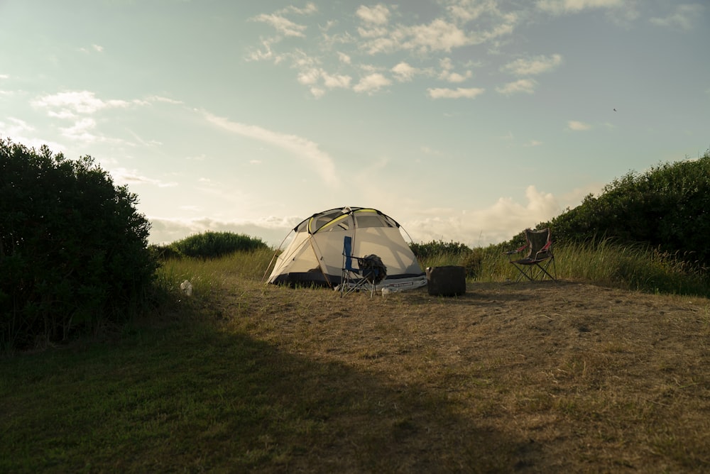 white tent on green grass field under white clouds during daytime