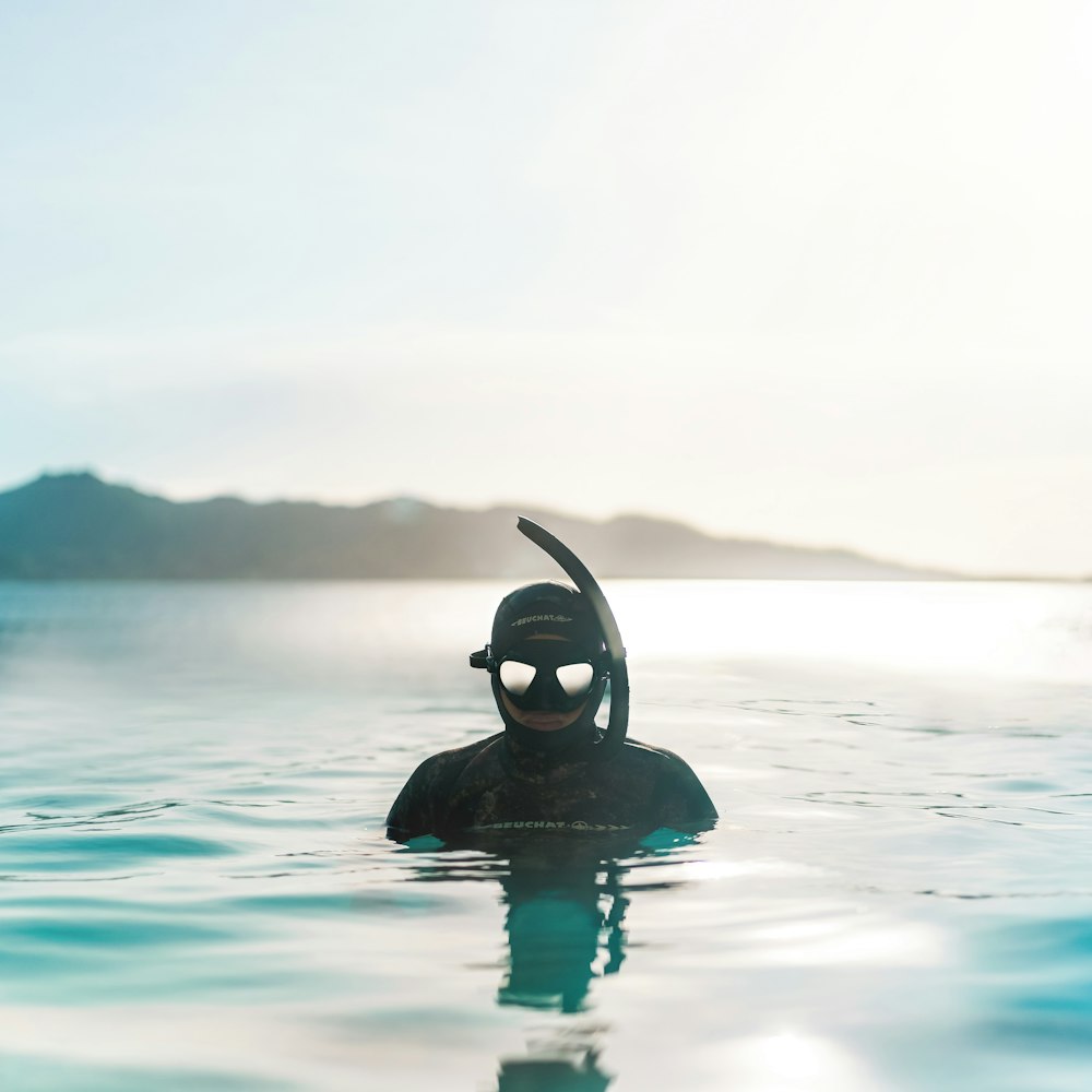 person in black swimming goggles in water
