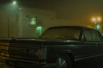 A classic vintage car parked under the glowing marquee of Fork Union Drive-In at dusk.