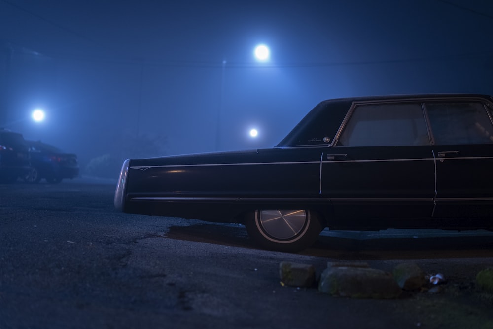 black sedan on gray asphalt road during night time