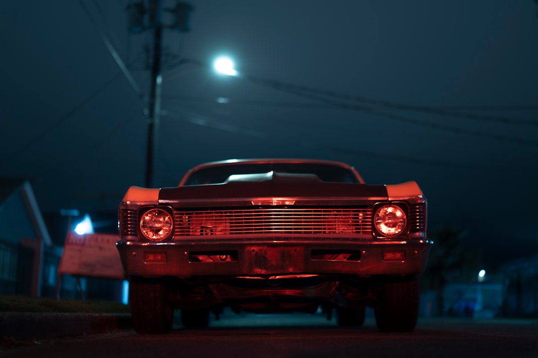 red chevrolet camaro on road during nighttime