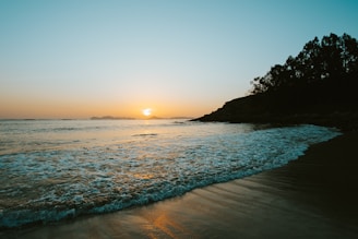 A tranquil beach scene with a sunset, symbolizing relaxation and adventure.
