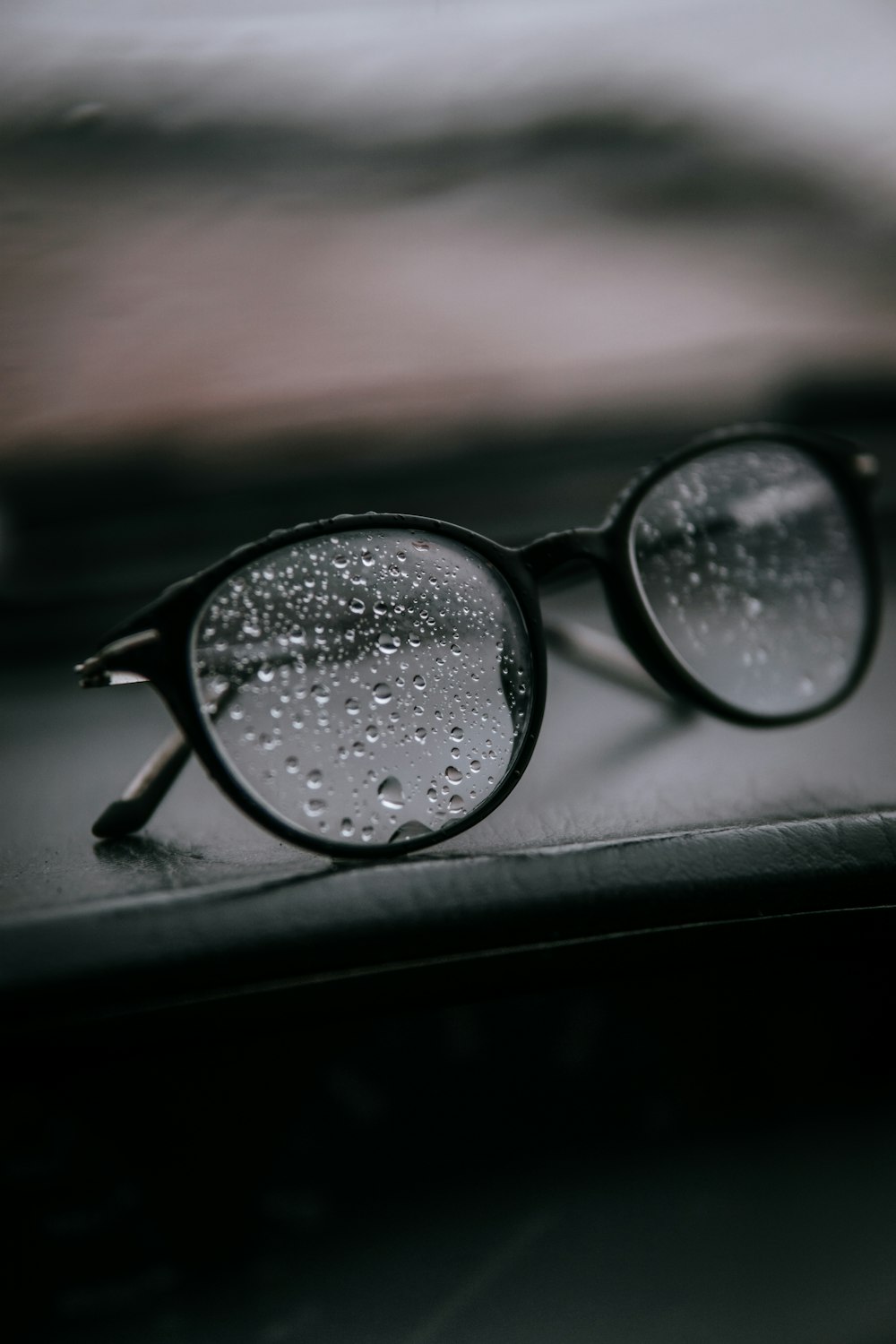 black framed eyeglasses on black surface