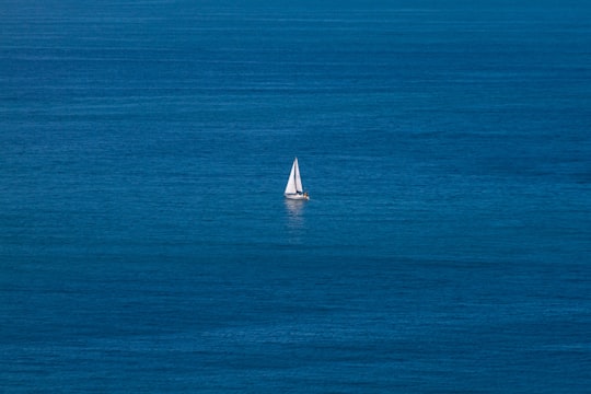 white sailboat on blue sea during daytime in Cape Point South Africa