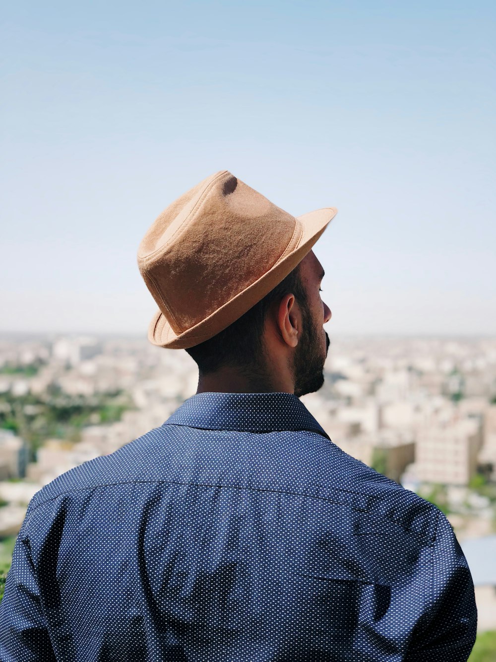 man in brown hat and blue and white checkered dress shirt