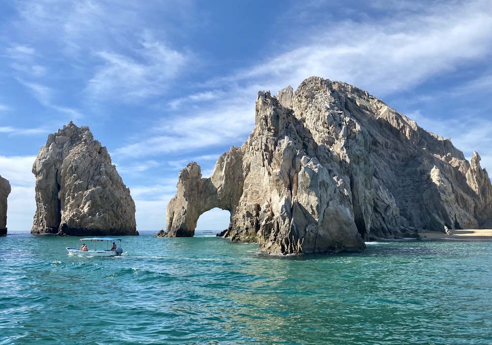 brown rock formation on sea under blue sky during daytime