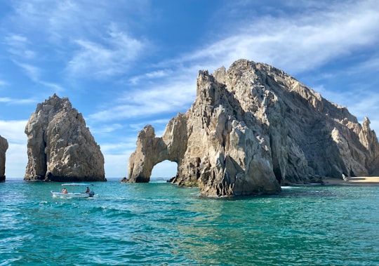 brown rock formation on sea under blue sky during daytime in El Arco de Cabo San Lucas Mexico