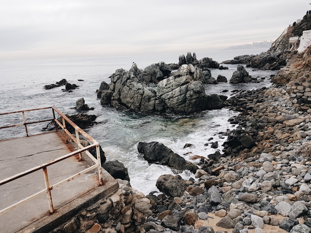 brown wooden ladder on rocky shore during daytime