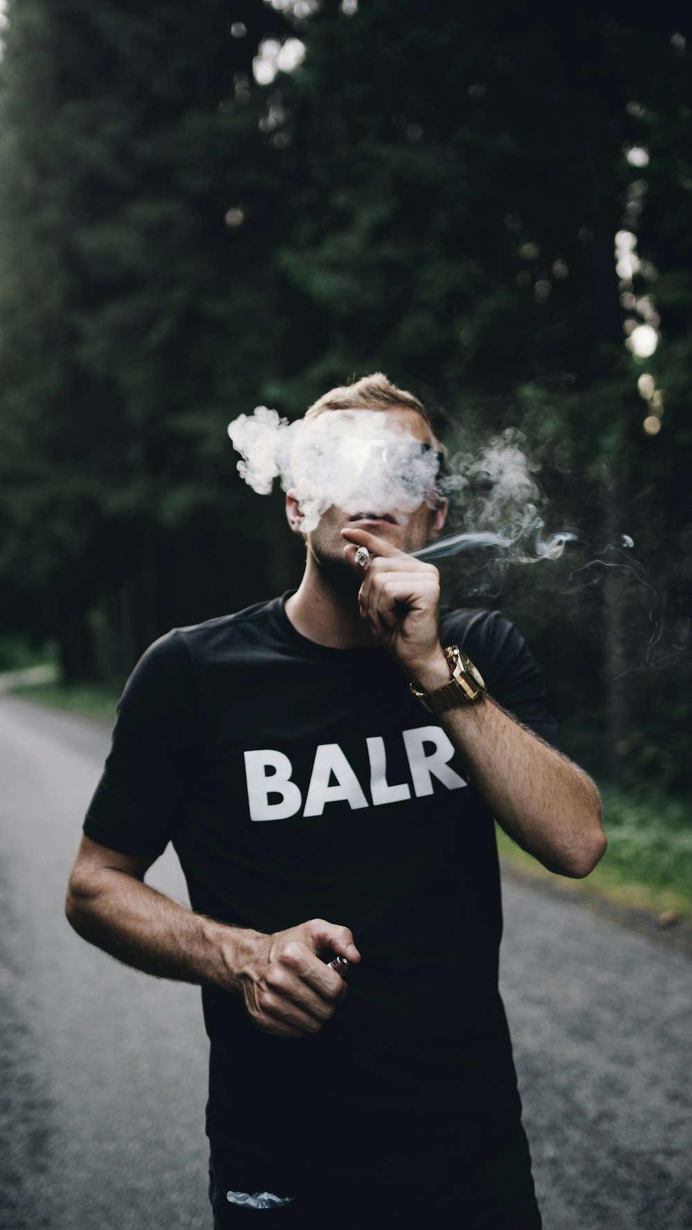 man in black crew neck t-shirt smoking cigarette