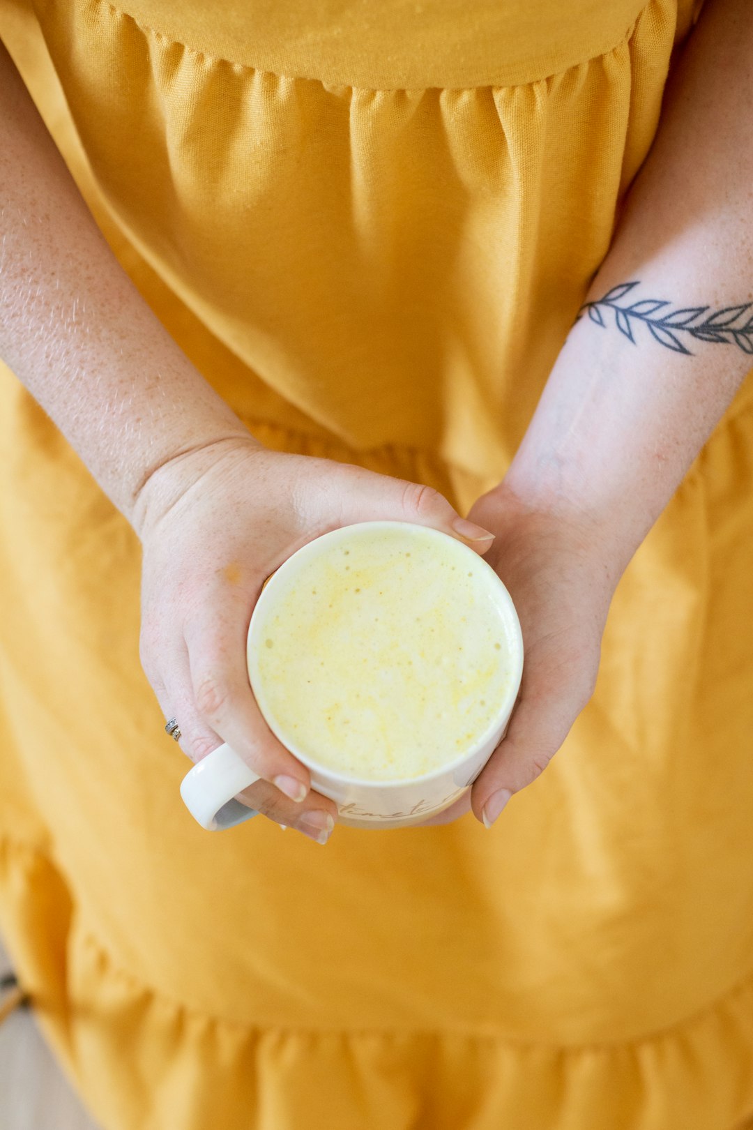 person holding white ceramic mug with white liquid