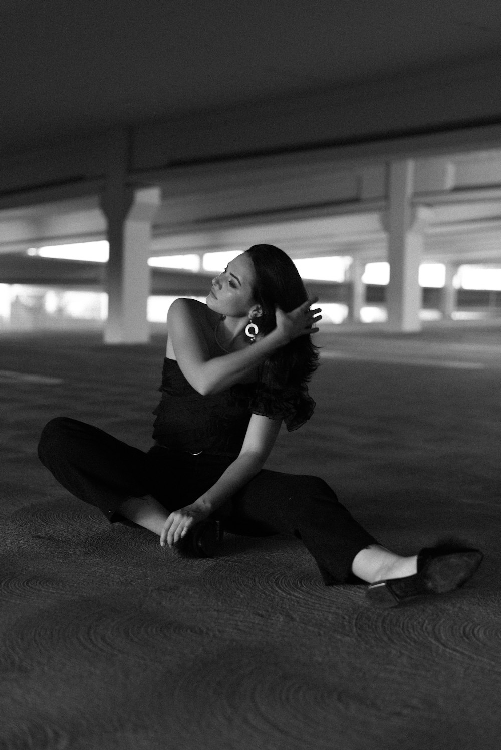 woman in black tank top and black pants sitting on ground
