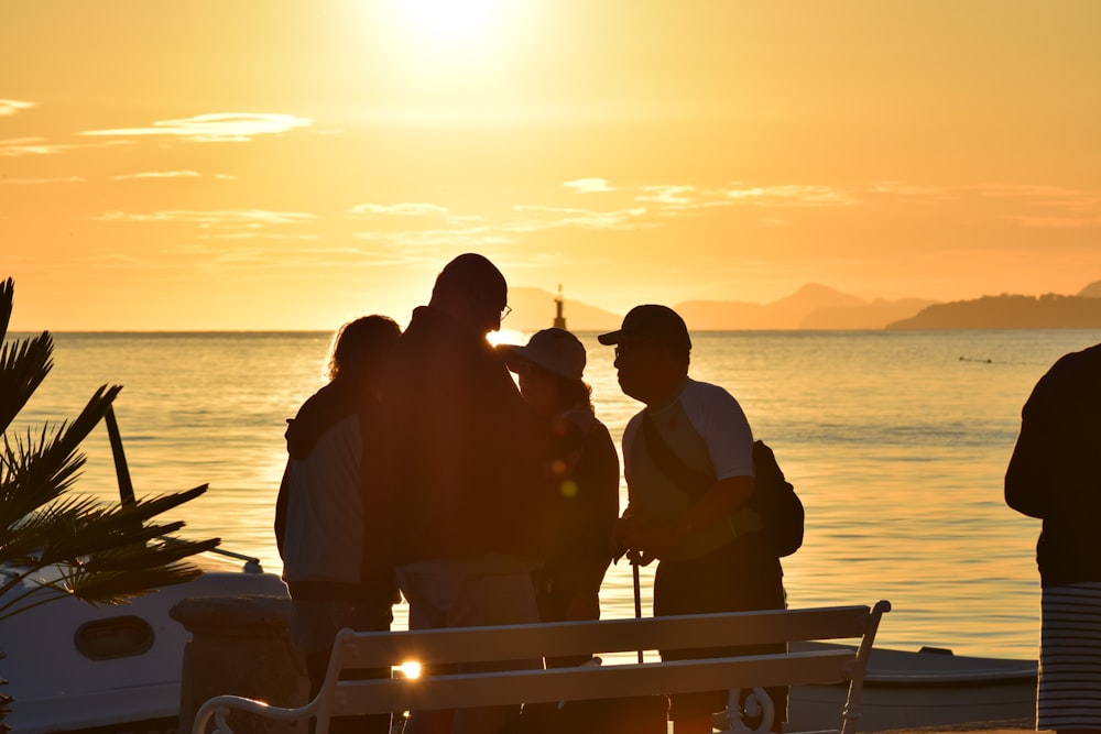 Silhouette von Menschen, die bei Sonnenuntergang auf dem Boot sitzen