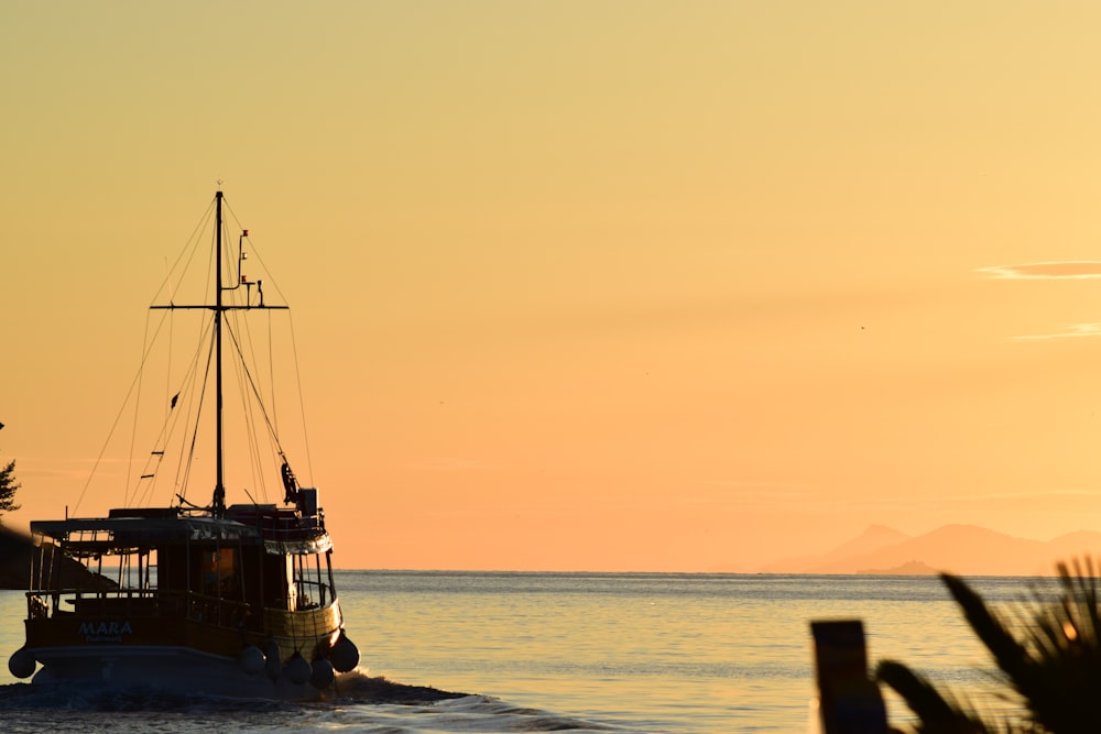 silhueta de barco no mar durante o pôr do sol