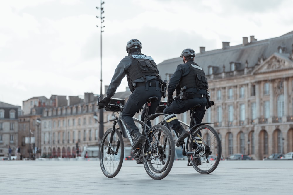 2 men riding on bicycle during daytime