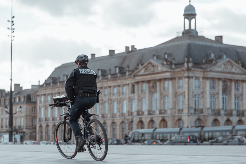 homme en veste noire faisant du vélo pendant la journée