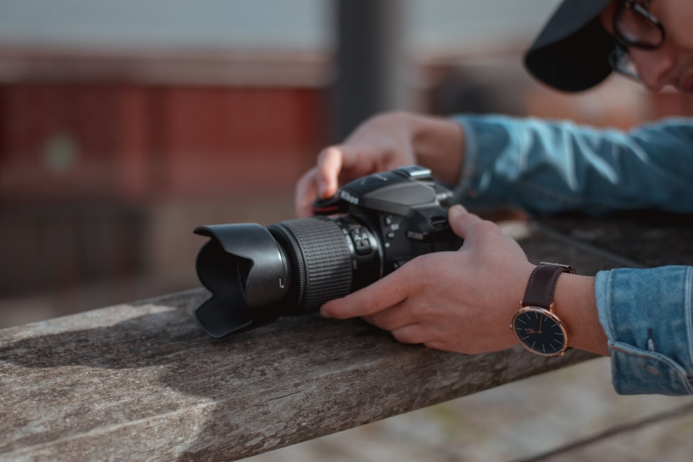 person holding black dslr camera