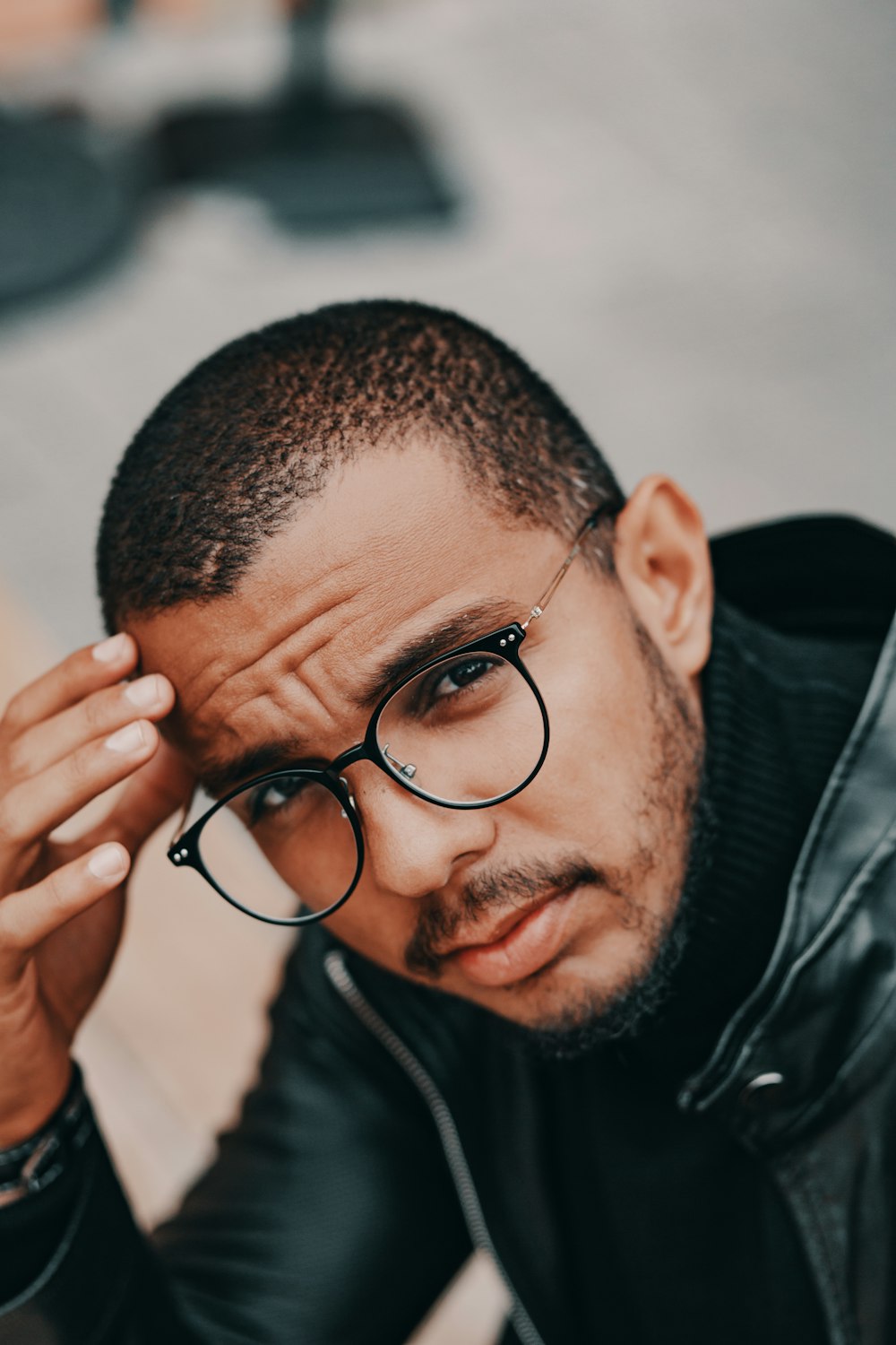 man in black framed eyeglasses and black jacket