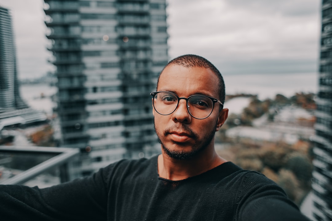 man in black crew neck shirt wearing black framed eyeglasses