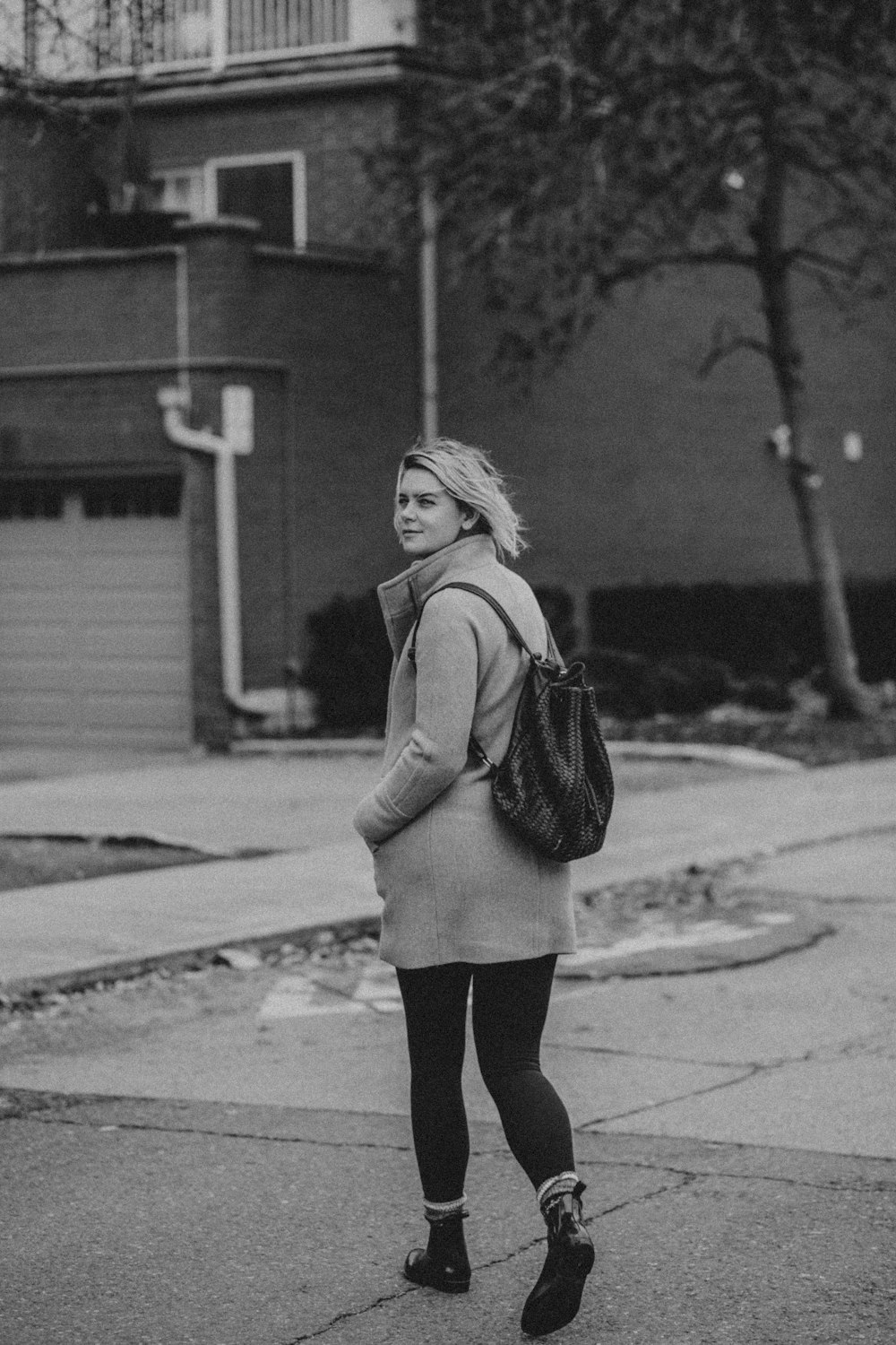 woman in jacket and pants standing on road