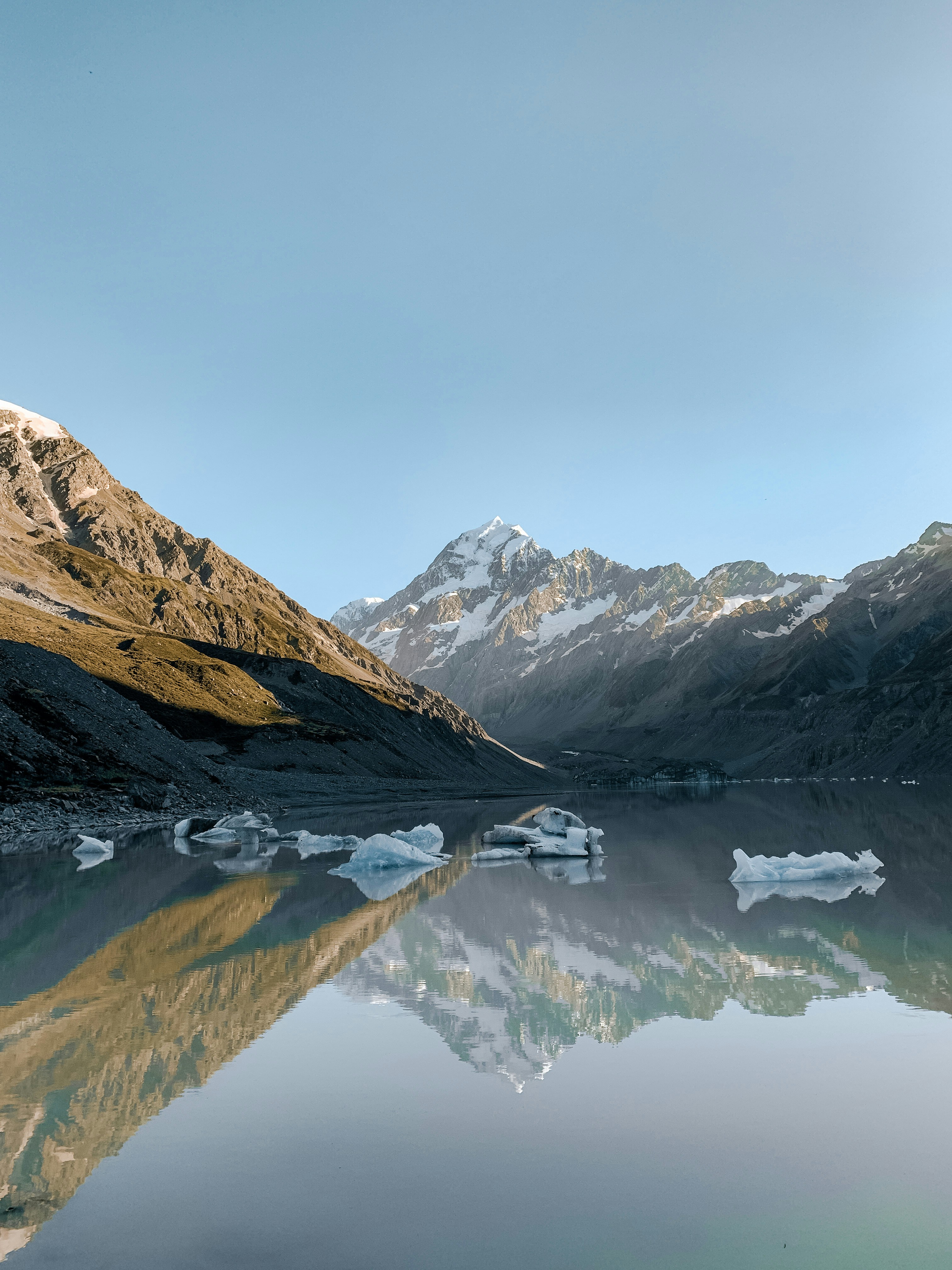 snow covered mountains near lake during daytime