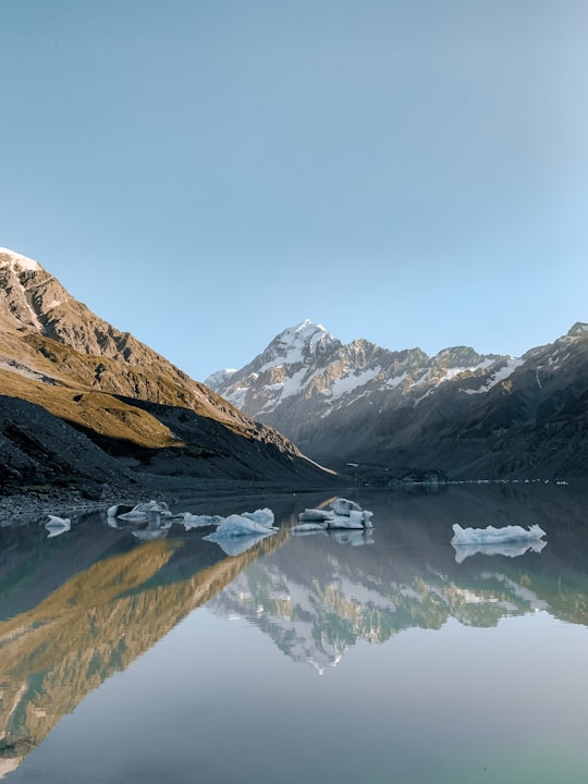 snow covered mountains near lake during daytime in Aoraki/Mount Cook National Park New Zealand