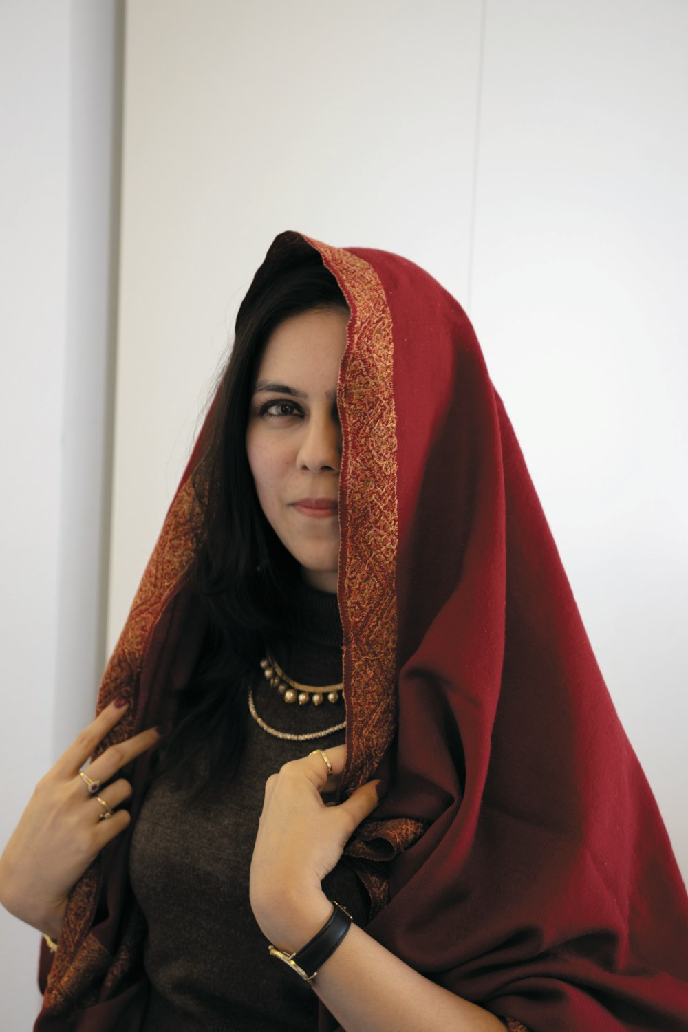 woman in red hijab covering her face with red textile