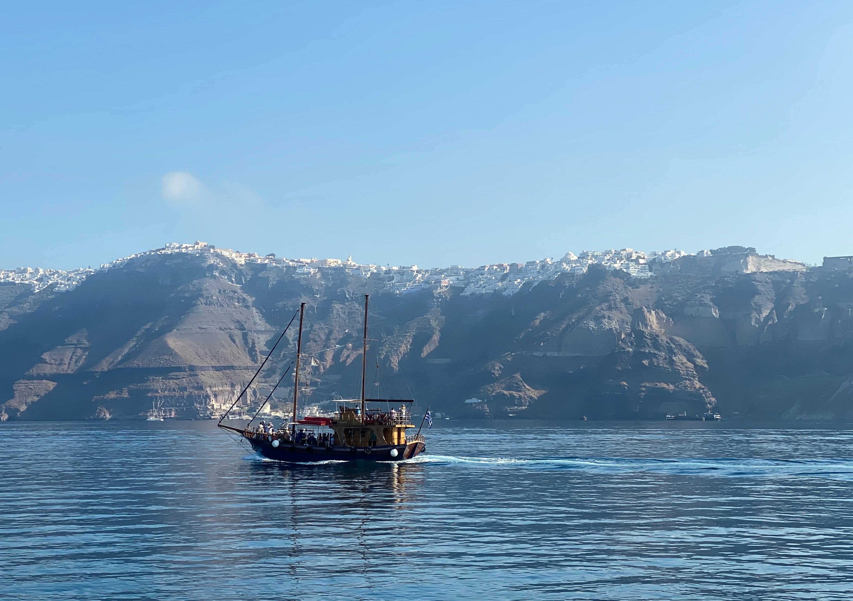 Bateau brun sur la mer près de la montagne enneigée pendant la journée