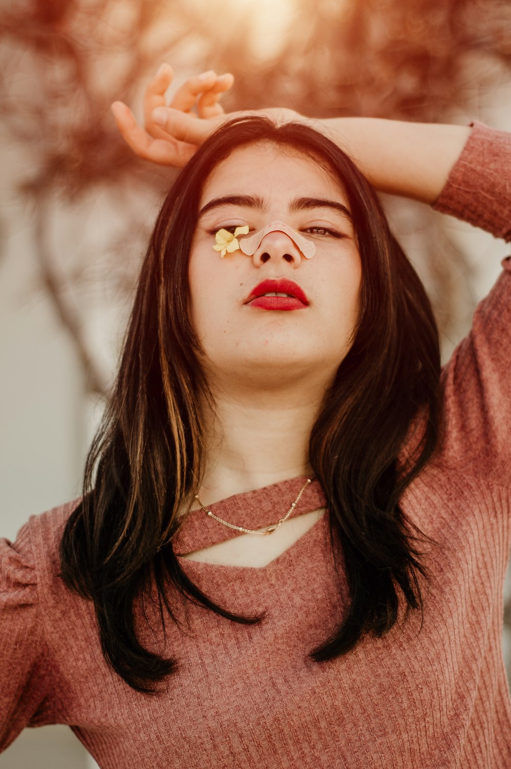 woman in red sweater with white pearl necklace