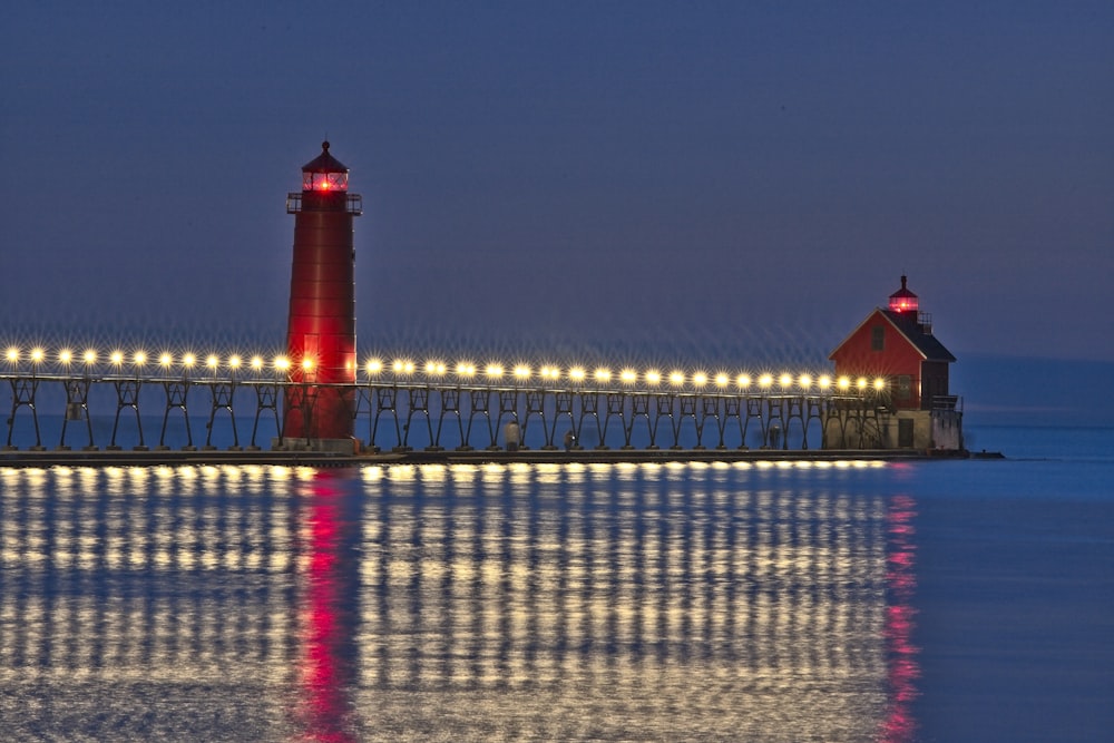 red and white lighthouse near body of water during daytime