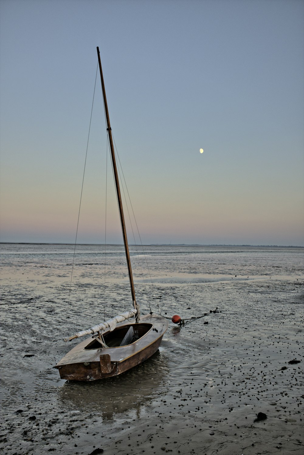 bateau blanc et brun sur la mer au coucher du soleil