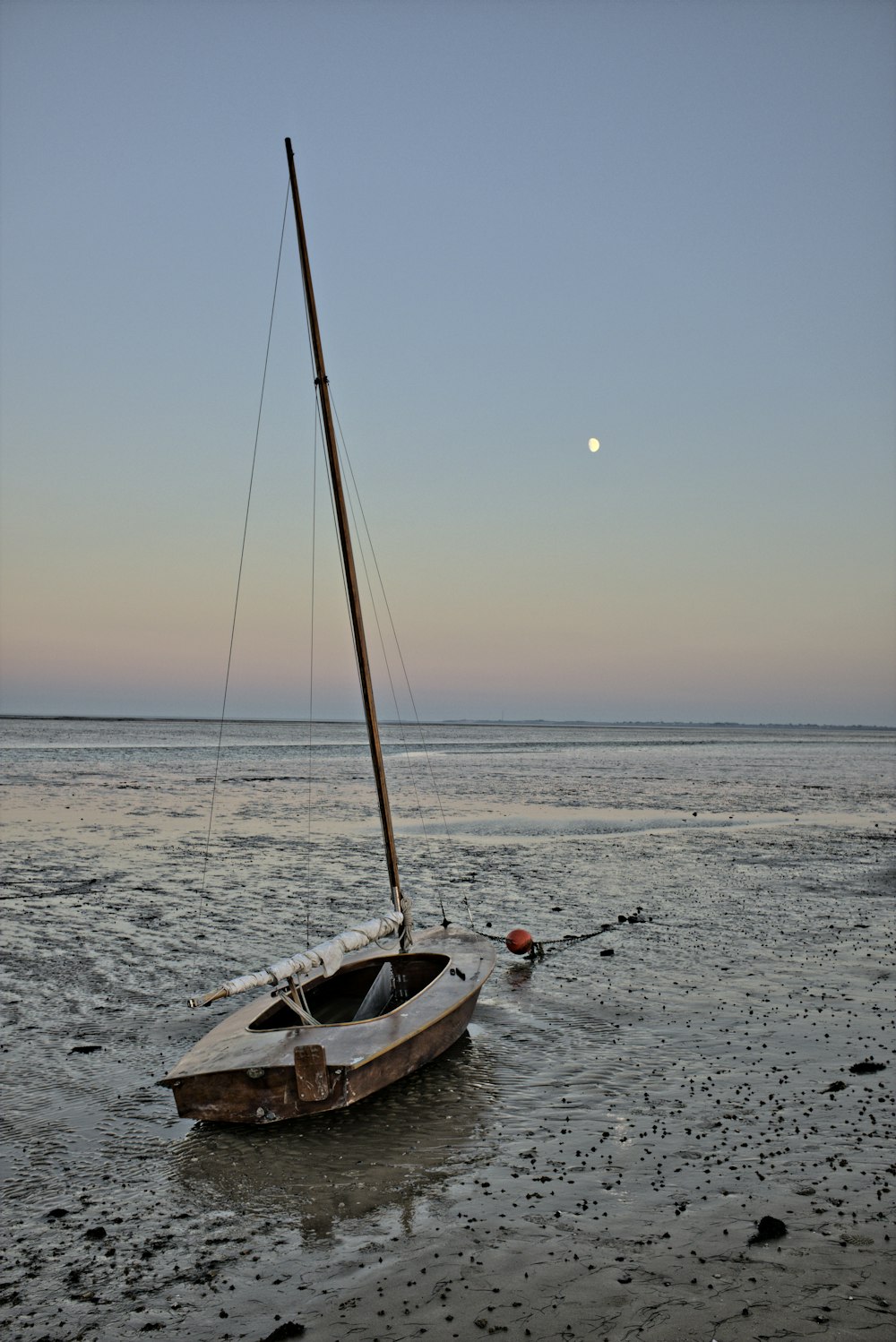 Barco blanco y marrón en el mar durante la puesta de sol