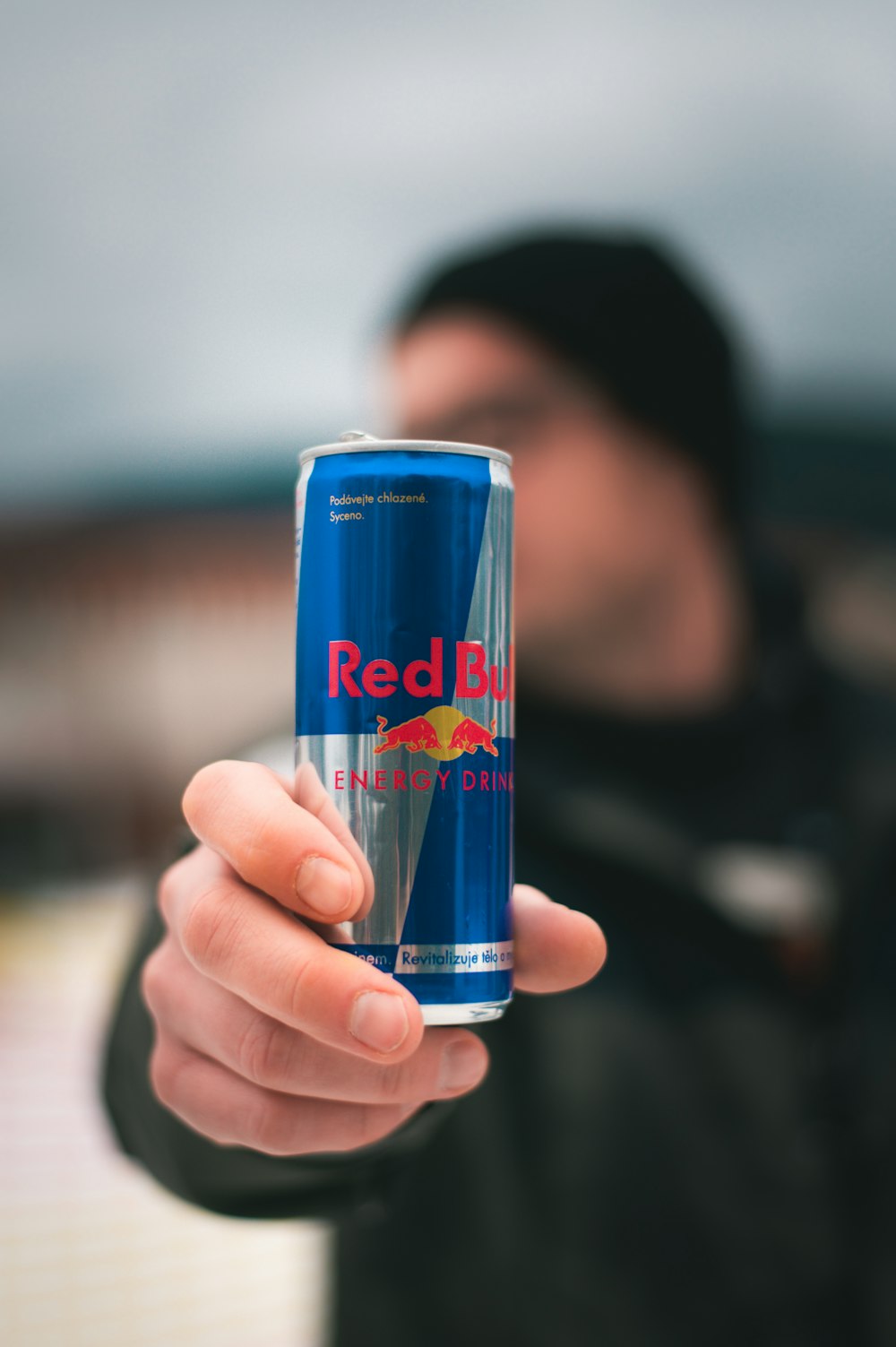 Person mit Red Bull Energy Drink Dose