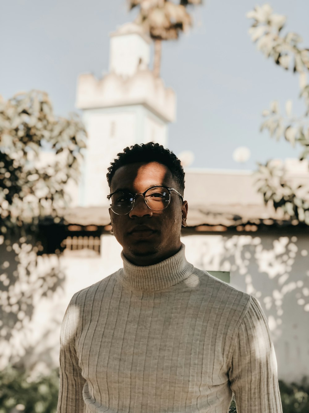 man in white knit sweater wearing black sunglasses