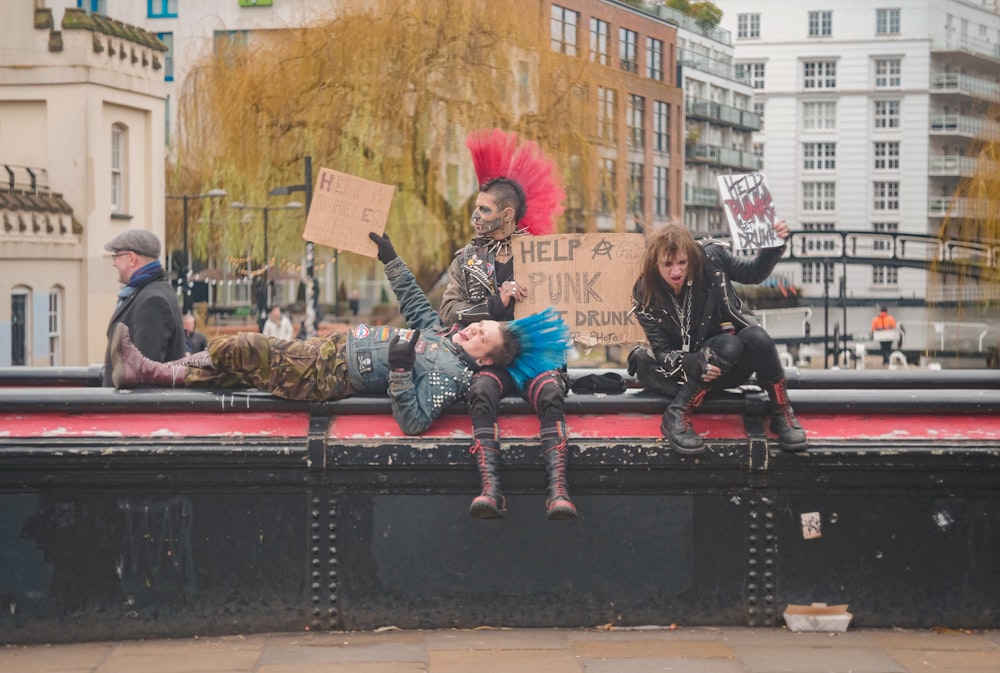 2 women sitting on black metal bench during daytime