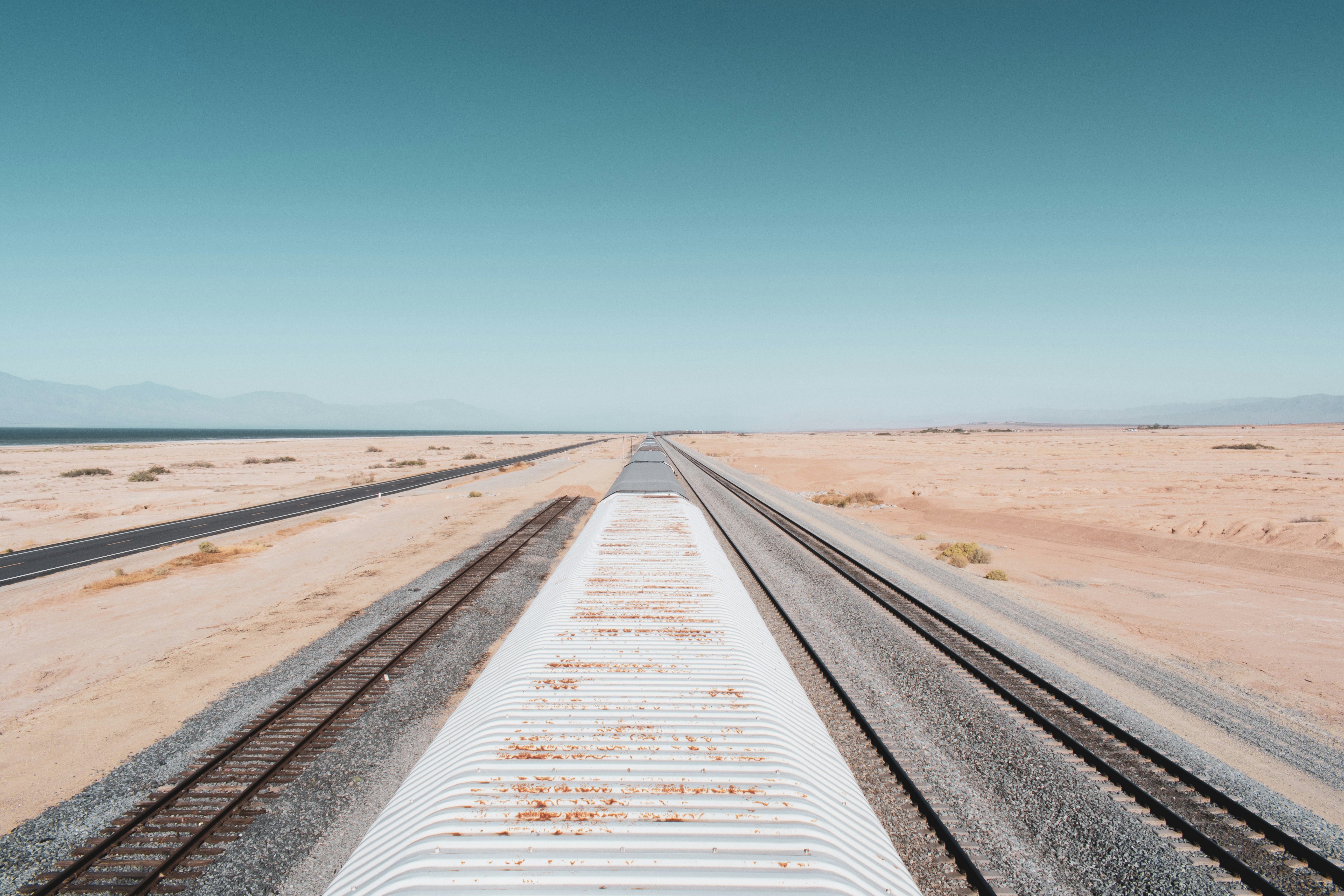 gray train rail under blue sky during daytime