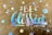 A decorative design features the words 'Be blessed' in iridescent rainbow lettering on a brown paper background. Surrounding the text are several circular dots also in a reflective rainbow pattern, giving a colorful and uplifting visual effect.