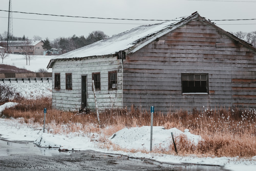 Casa de madera marrón en suelo cubierto de nieve